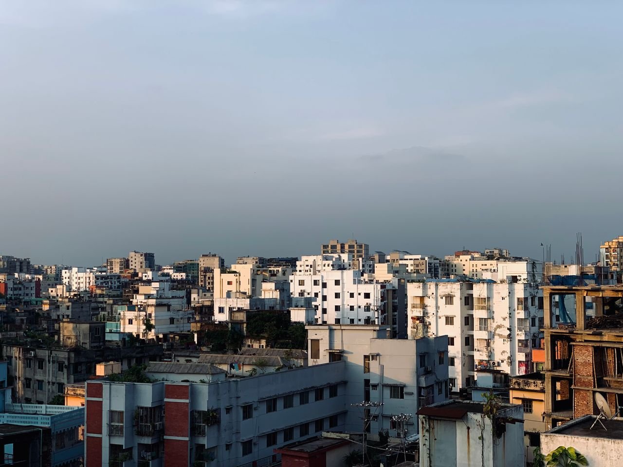 Aerial view showcasing the densely packed residential architecture of Dhaka under a clear sky.