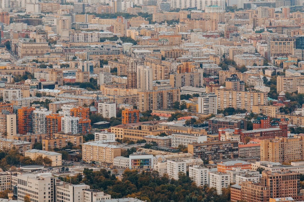Expansive view of urban residential and commercial buildings from high above, showcasing city life.